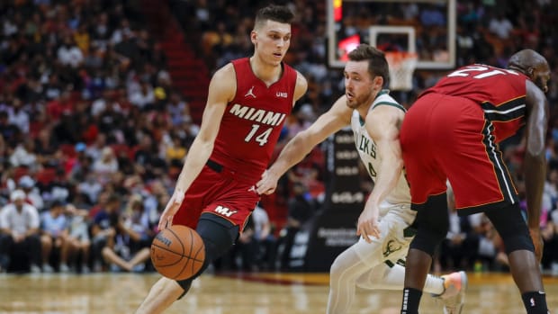 Oct 21, 2021; Miami, Florida, USA; Miami Heat guard Tyler Herro (14) dribbles the ball around Milwaukee Bucks guard Pat Connaughton (24) during the fourth quarter of the game at FTX Arena. Mandatory Credit: Sam Navarro-USA TODAY Sports